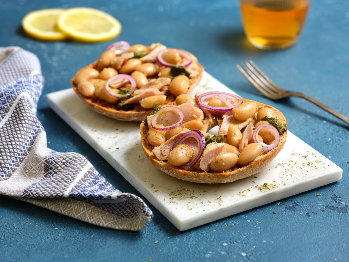 Whole wheat friselle with beans, fresh onion, basil pesto sauce, and tuna 